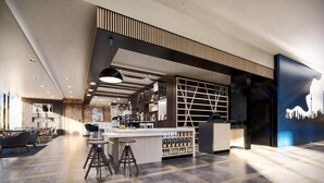 A modern hotel lobby with a bar area, seating, and a staircase. - Hyatt Place Toronto Airport (TORONTO)