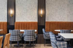 Een restaurantinterieur met ruimtes, tafels en modern decor.