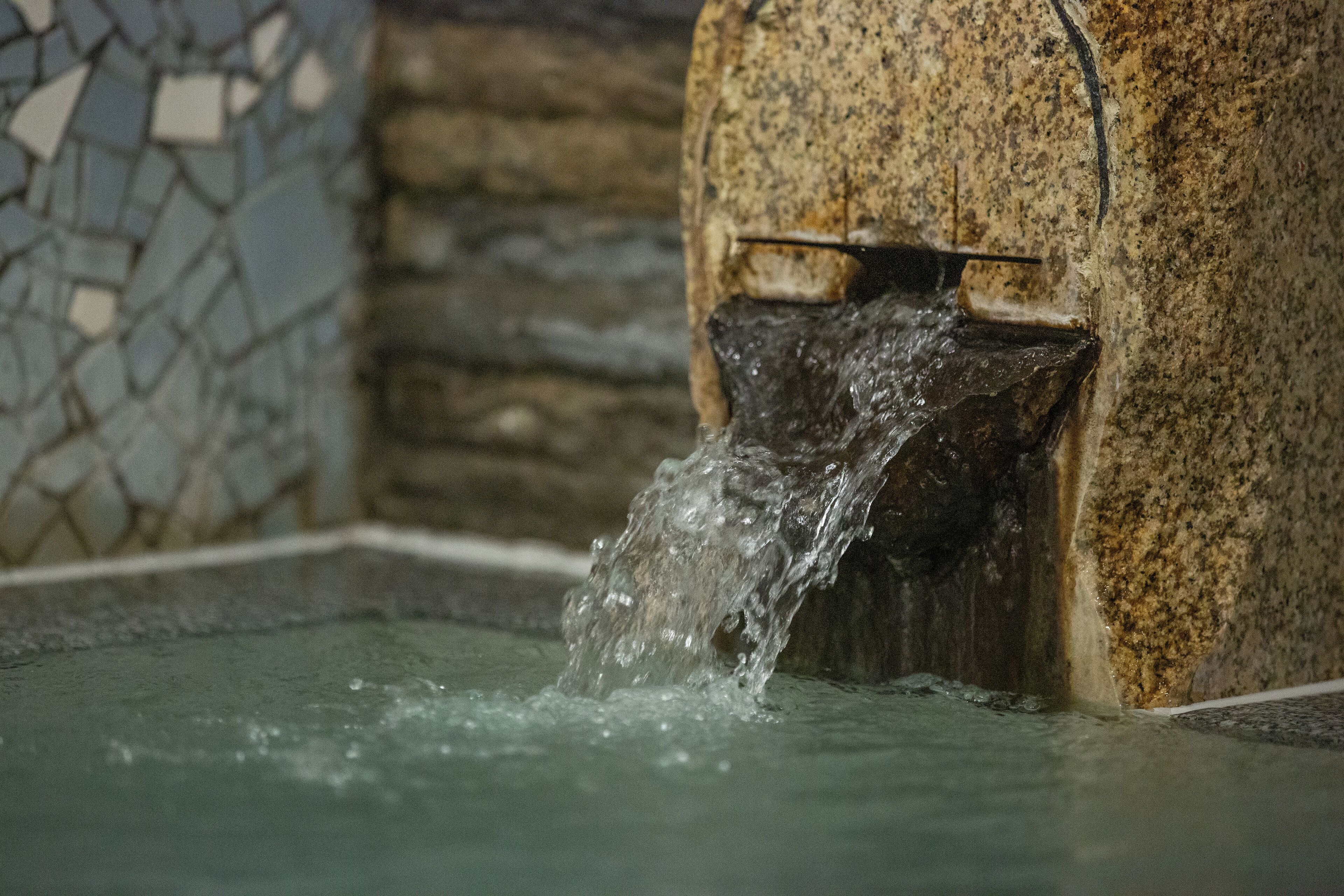 Un muro de piedra con una fuente de agua.