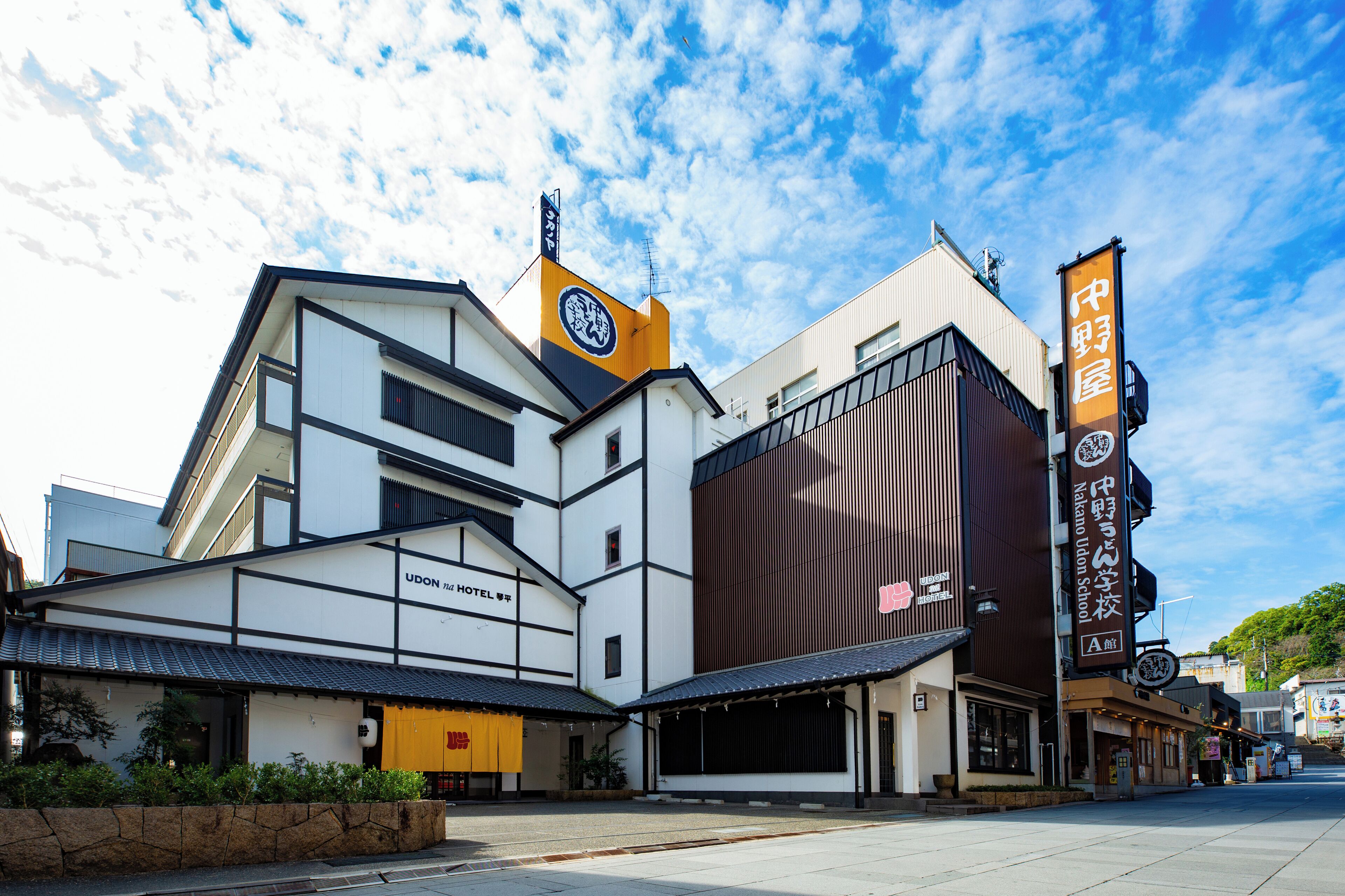 En moderne bygning med skiltning for Udon Hotel og et stort skilt for Nakano Union School.