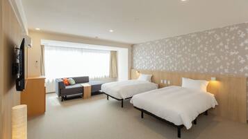 Habitación de hotel con dos camas, un sofá, un televisor y una ventana con cortinas.