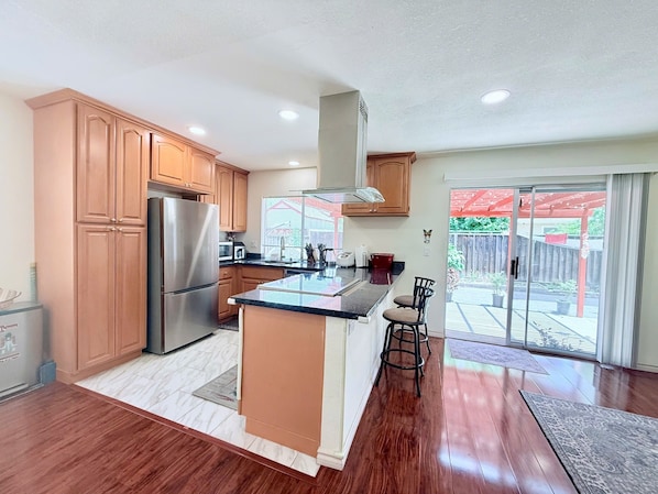 Una cocina moderna con armarios de madera, electrodomésticos de acero inoxidable y una isla grande.