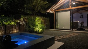 A modern outdoor pool area with a wooden deck and a glass-enclosed structure. - Lembos Cabin with Jacuzzi and sky view (Pereira)