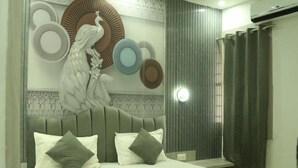 Una scala conduce a un pianerottolo con una parete decorata e una ventola a soffitto.
