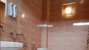 A bathroom with a white sink, toilet, and shower. - SUMARU JUNGLE RESORT (Alipurduar)