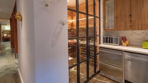 Eine moderne Küche mit Weinkeller, Edelstahlgeräten und Holzausstattung.
