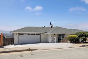 A single-story house with a garage, a small porch, and a clear sky.