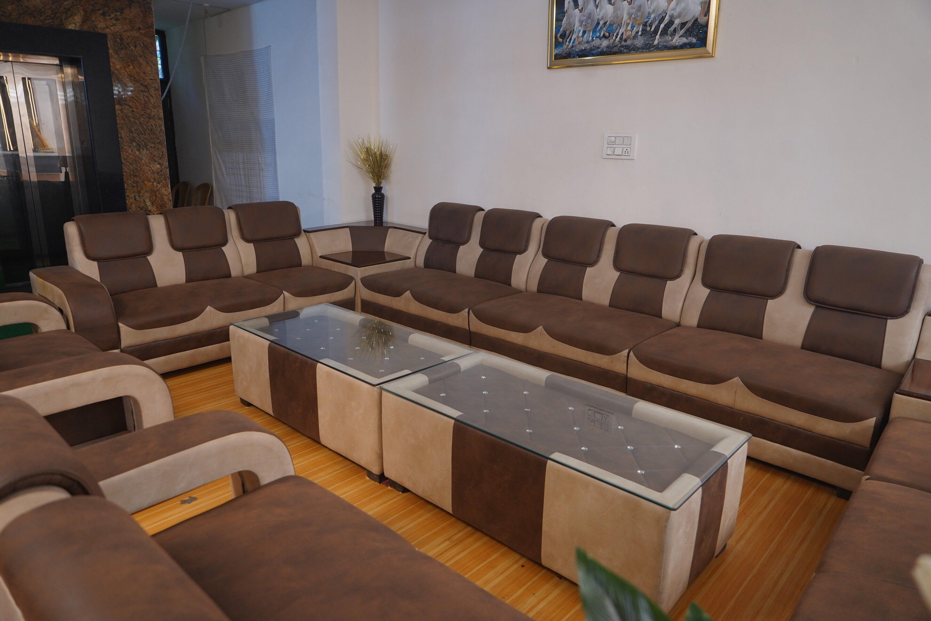 Un salon moderne avec un canapé d’angle, une table basse en verre et une plante en pot.