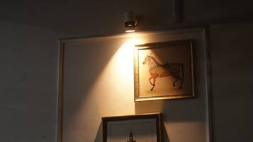 A wall with three framed pictures: a horse, a building, and a bull.