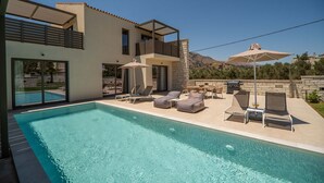 A modern house with a swimming pool, outdoor seating, and a view of the mountains. - Villa Zen Hera – Vacation villa in Crete (Georgioupolis)