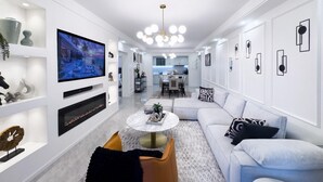 A modern living room with a TV, sofa, coffee table, and decorative items. - Alba Gardens B1102 (Nairobi)