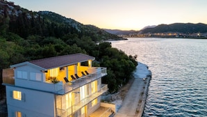 Ein Küstenhaus mit Balkon und Meerblick, einem Essbereich und Ausblick auf die umliegende Landschaft.