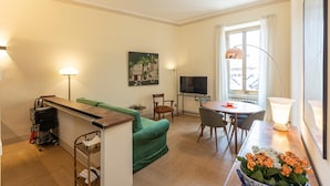 A compact living space with a sofa, a dining table, and a TV.
