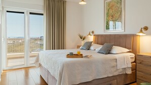 Una camera da letto con un letto, comodini, tende e vista all'esterno.