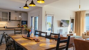 Una cucina moderna con un tavolo da pranzo in legno, sedie nere e lampade a sospensione.
