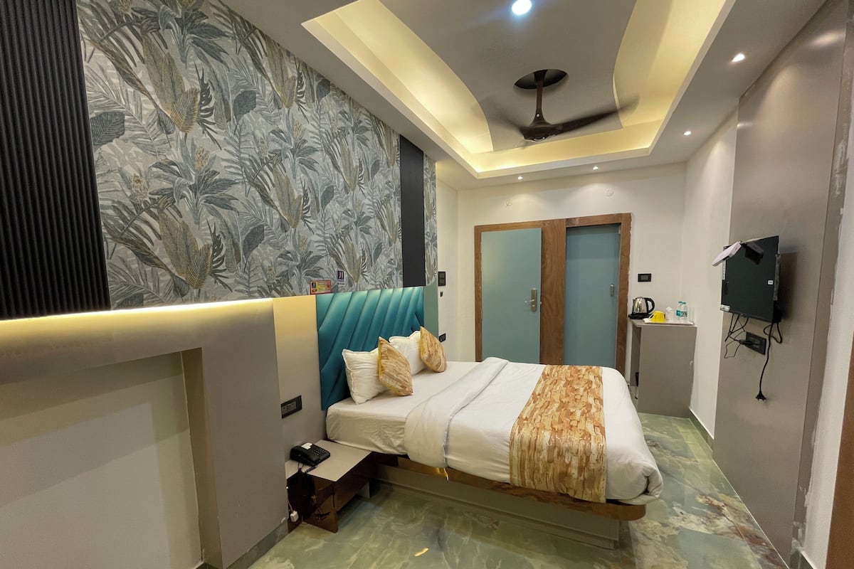 Ein modernes Hotelzimmer mit Bett, Schreibtisch, Kleiderschrank und Deckenventilator.