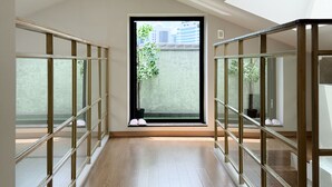 Una habitación con tragaluz, un ventanal y vistas a edificios.