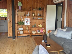 Puisesti sisustettu huone, jossa on sohva, sohvapöytä ja kirjahylly.
