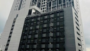 Un immeuble moderne de grande hauteur, doté d’une façade à motifs géométriques et de nombreux balcons.