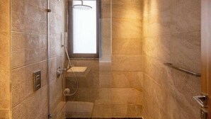 A modern bathroom with a glass-enclosed shower, a toilet, and a sink. - Kennah Meraviglia | Lake View Residence, New Cairo (New Cairo)