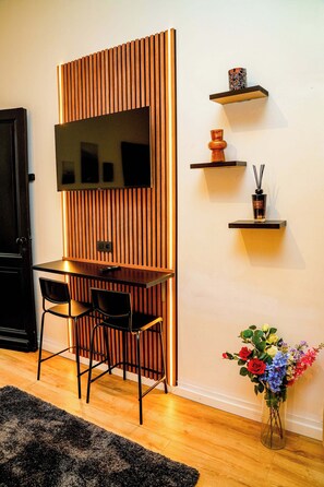 Habitación básica | Espacio para trabajar con laptop y tabla de planchar con plancha