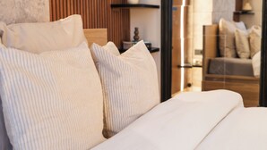 A neatly made bed with white linens and a wooden headboard. - Comfy 5BR Apartment in Heart of Ghent (Ghent)