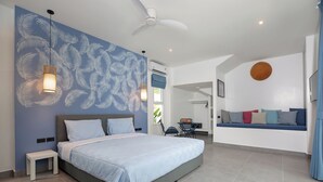 A modern bedroom with a large bed, a ceiling fan, and a wall with a leaf pattern.