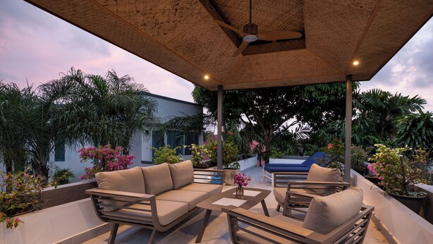 An outdoor patio area with a sofa, chairs, and a table.