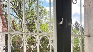 A wrought iron gate with a stone pathway leading to a garden area. - Daphne Estate (Aia Vecchia)