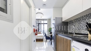 Ett modernt kök med kakel ovanför arbetsbänken, en inbyggd tvättmaskin och en matplats med utsikt.