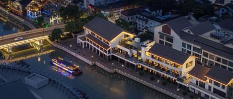 A riverside hotel with multiple floors, a covered walkway, and a boat dock.
