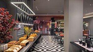 A modern hotel lobby with a checkered floor, a long buffet table with various food items, and a seating area with tables and chairs. - SSAW Garden Hotel Suzhou (Suzhou)