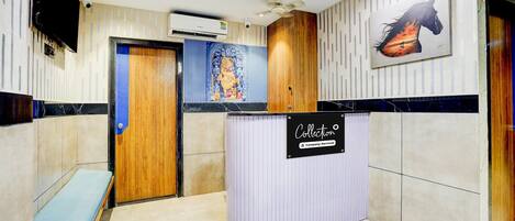 A reception area with a wooden bench, a reception desk, and a wall-mounted sign.