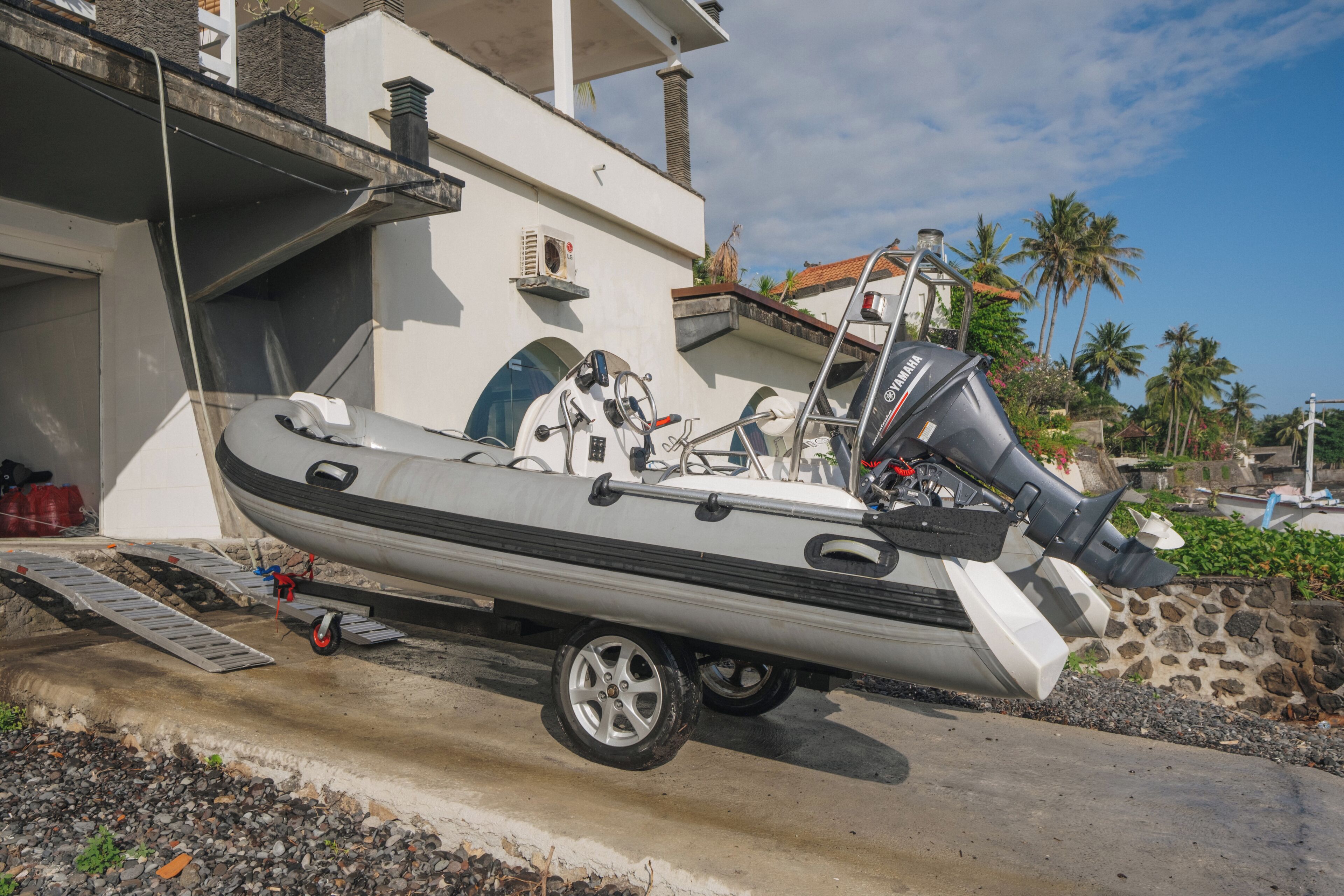 A motorboat on a trailer parked on a driveway.