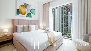 Une chambre d’hôtel moderne avec un grand lit, une table de chevet, une lampe et une vue sur la ville.