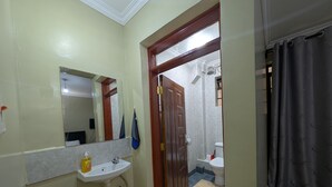 A bathroom with a sink, mirror, and shower area. - Live Light, Live Right.Fully-Furnished Studio Apartment in Machakos! (Machakos)