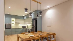 Una cocina moderna con armarios grises, horno empotrado y microondas.