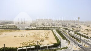 A large, open area with a road and buildings in the background. - Bloomfields Homey Stu The Gate Masdar  (Abu Dhabi)