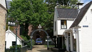 A narrow street with a white building labeled "B&B de Thuisaker" and a sign "WIDE STEEG" on the right. - Nice holiday home on the water in Grou (Grou)