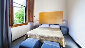 A bedroom with a large bed, a nightstand, a window with curtains, and a view of greenery outside. - BB Melody House (Florence)
