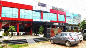 A hotel with a red and black facade, a visible restaurant named "Family Restaurant," and a sign for "HOC Spice."