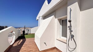 A rooftop terrace with a shower, a small window, and a view of the sea. - Tiny Loft Skydeck (Civitavecchia)