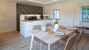 A modern kitchen with white cabinets, a wooden countertop, and a built-in coffee machine. - Fantastic guest house on the Elbe cycle path and Bastei (Rathen)