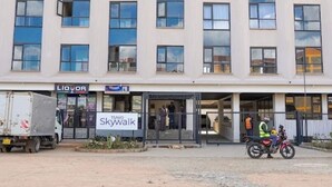 Un immeuble à plusieurs étages dont le rez-de-chaussée abrite un commerce appelé « Skywalk ».