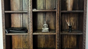 A wooden cabinet with intricate carvings and multiple shelves. - Southend luxe retreat (Southend-on-Sea)
