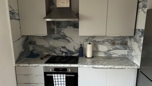 A kitchen with a built-in oven, a microwave, and a stainless steel range hood. - Southend luxe retreat (Southend-on-Sea)