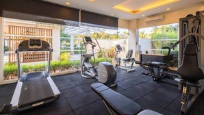 A modern gym with treadmills, elliptical machines, and weight equipment. - VIP Dream Suite Residence Krabi (Krabi)