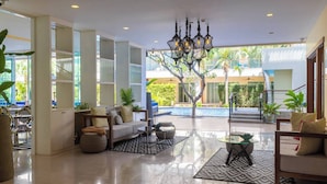 A spacious lobby with a modern chandelier, comfortable seating, and a view of a swimming pool. - VIP Dream Suite Residence Krabi (Krabi)