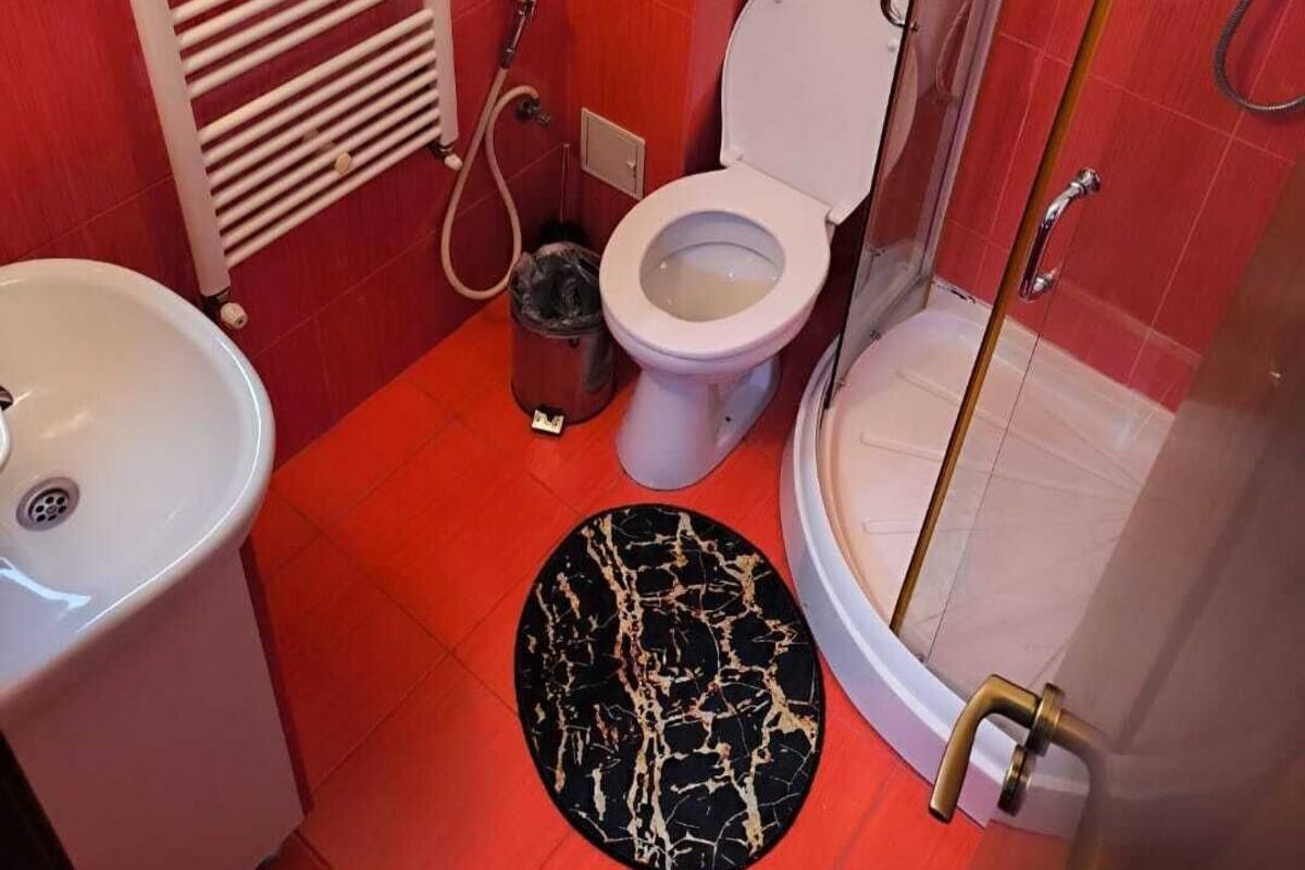 A bathroom with a toilet, sink, and shower.