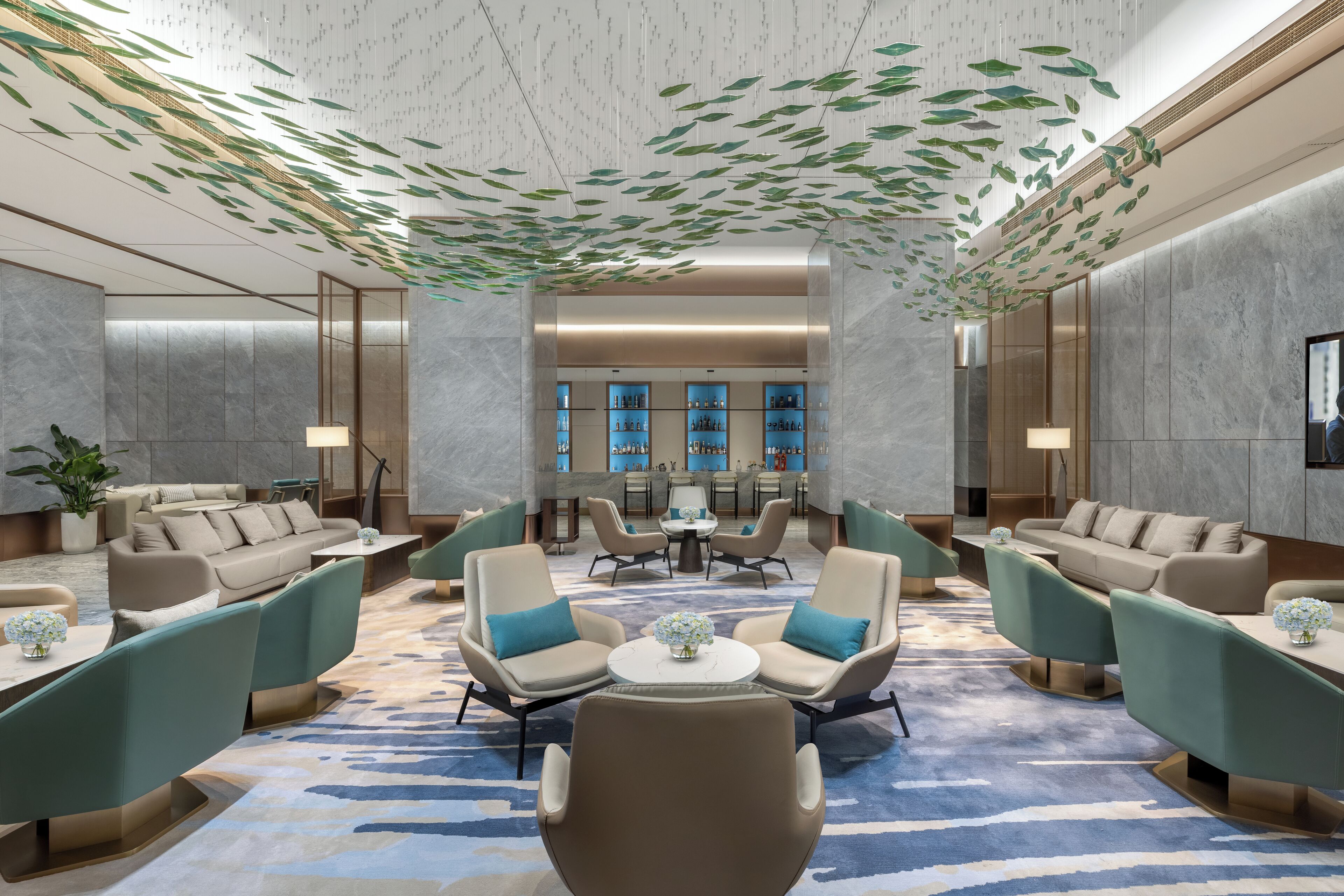 Eine moderne Lobby mit Sitzbereichen, einem Empfangstresen und einem großen Fenster.